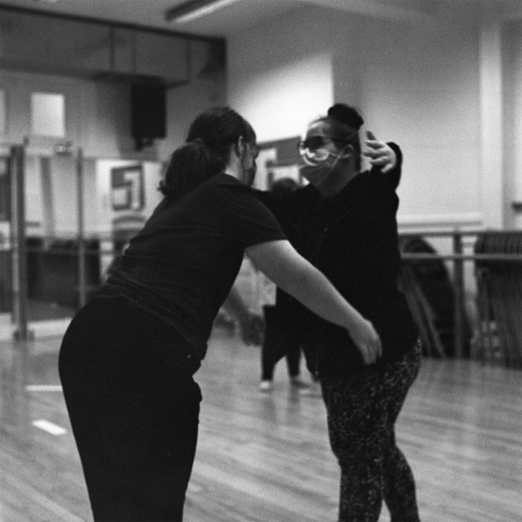 A black and white image of two dancers rehearsing a duet