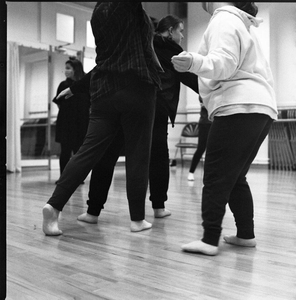 A black and white photo of dancers in their rehearsal studio.