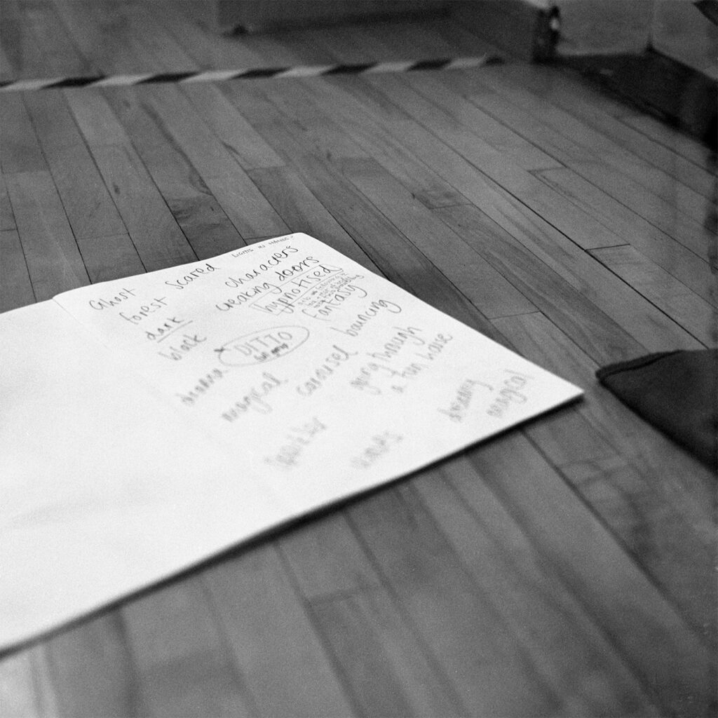 A black and white image of a notebook on a wooden floor